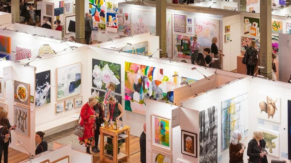 Visitors browsing artwork in a gallery exhibition.