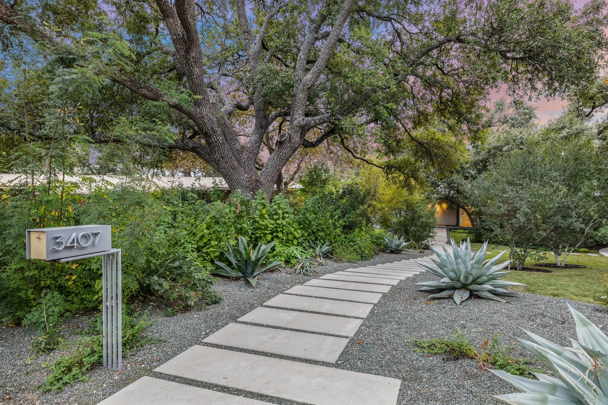 The 3407 house number marker at the start of a paver walk through agave and gravel