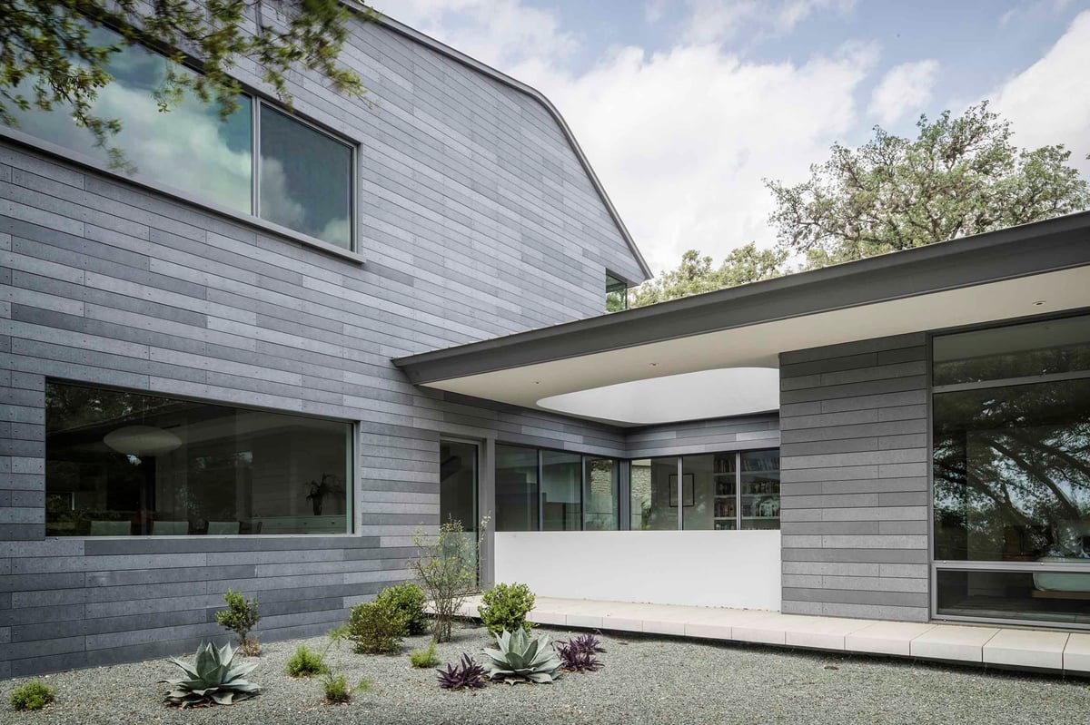 Two clad wings of the house meeting over a gravel and agave garden