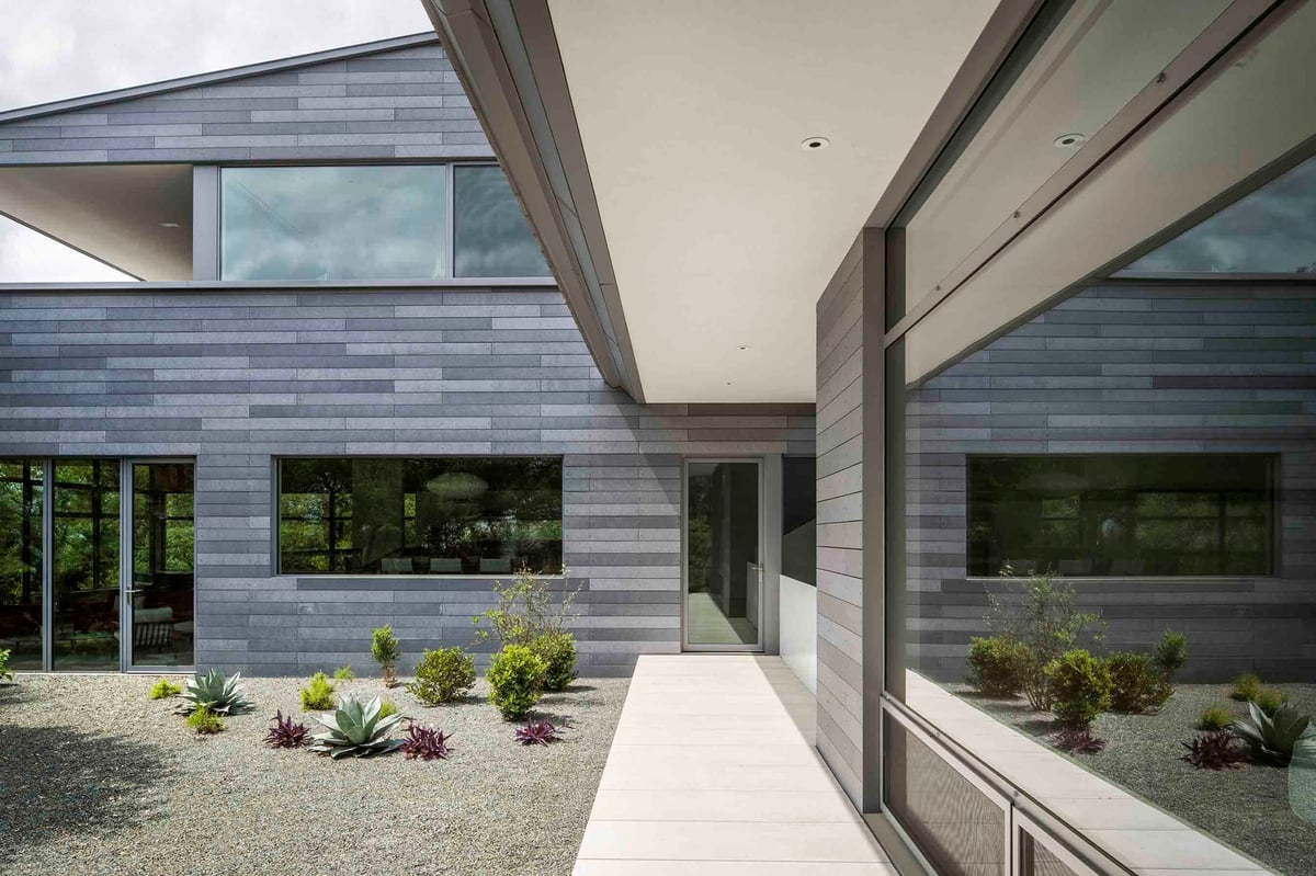 A concrete walk along the clad wing and a gravel garden