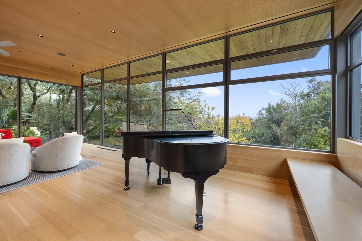 Grand piano in the corner of the great room with glass on two sides