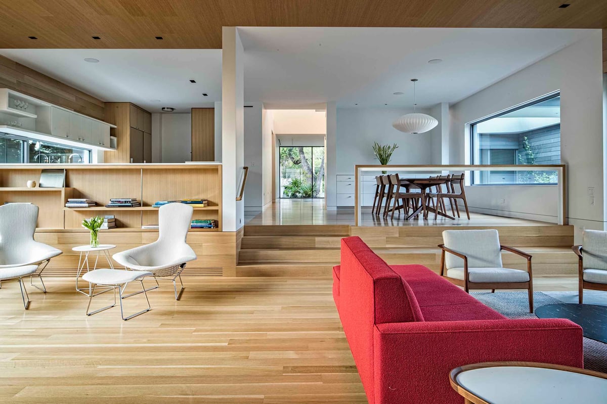 Great room lounge chairs and red sofa with the dining room beyond