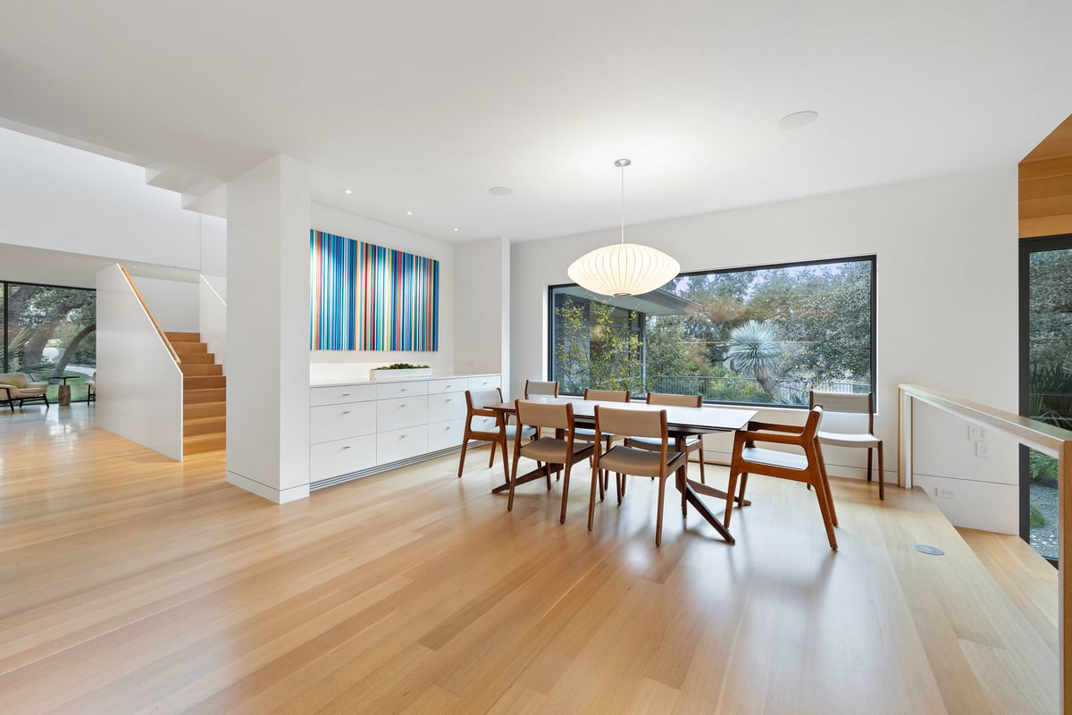 Dining room with a paper pendant, a wall of built-ins and the stair beyond