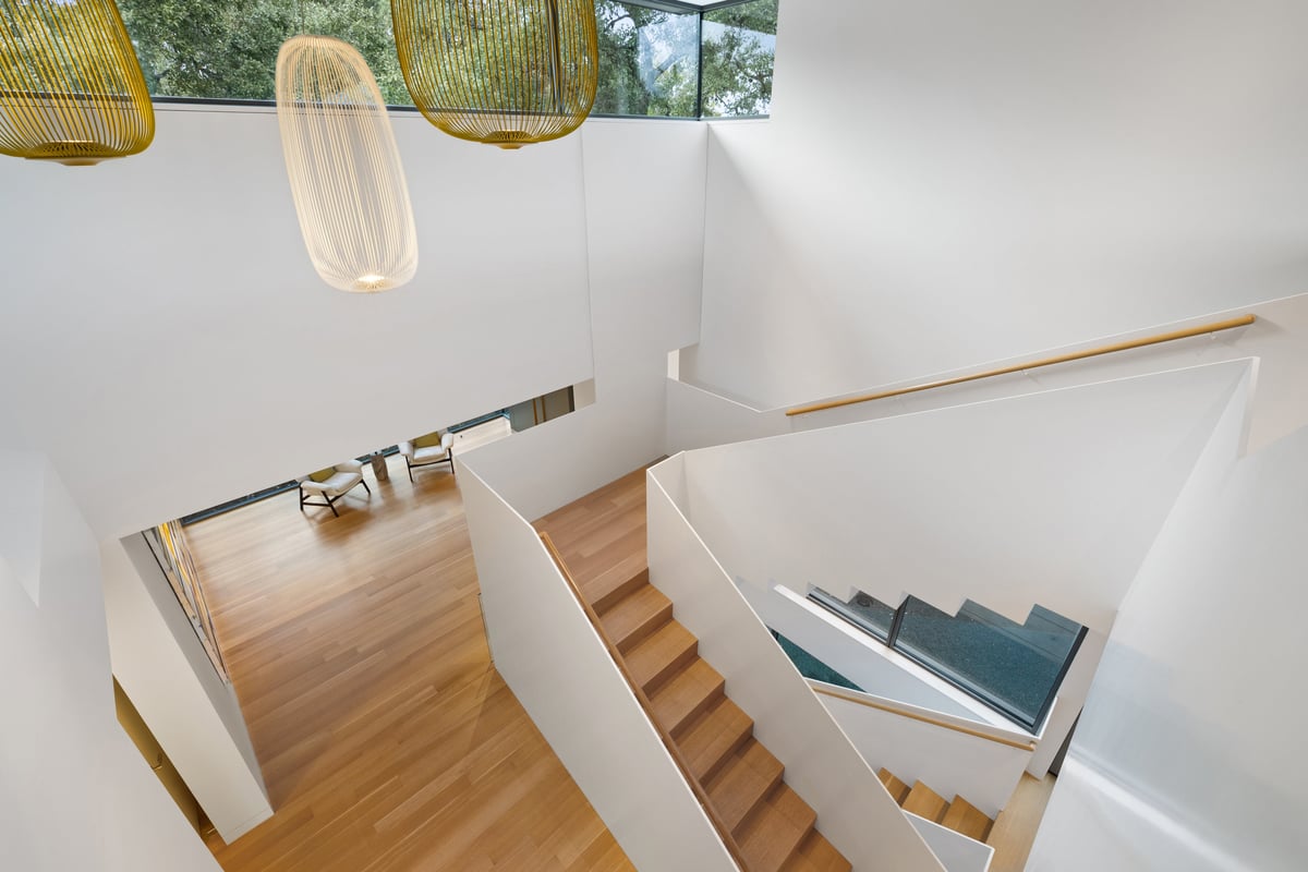 Looking down the open stair under a hanging pendant