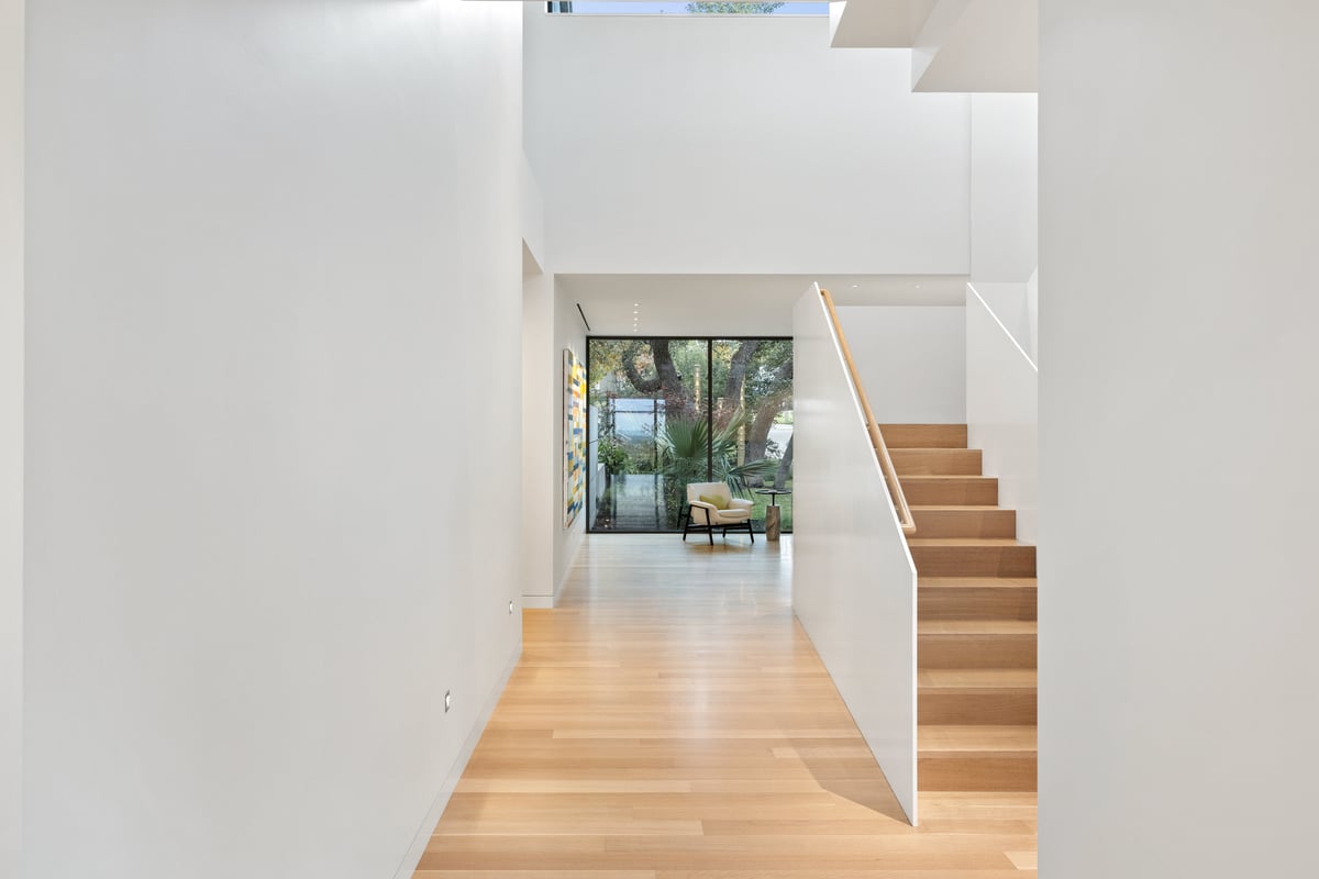 Stair hall leading to a glass door and the garden