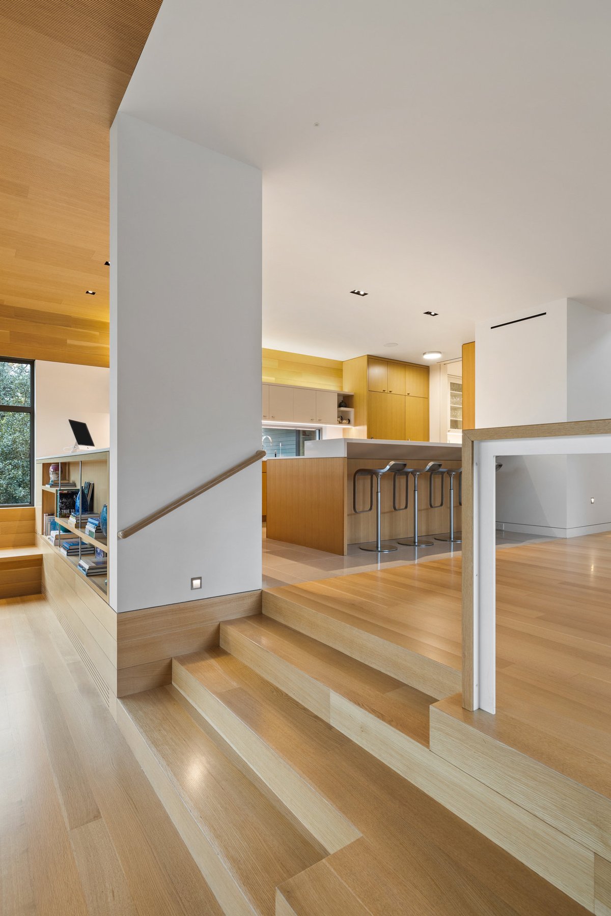 Oak steps and a built-in bench where the great room meets the kitchen level