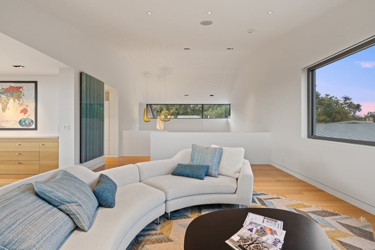 Upstairs lounge with a curved sofa and a clerestory window above the bar