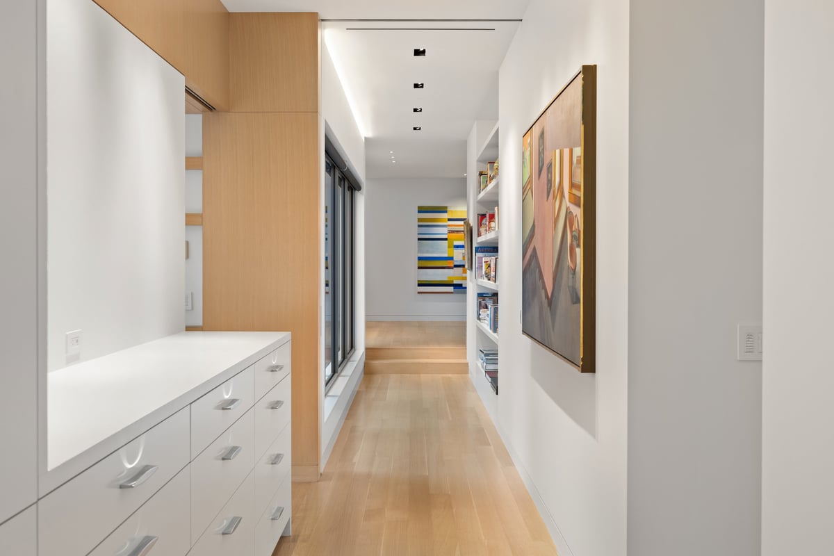 Dressing hall with white built-ins, oak panels and an artwork at the end