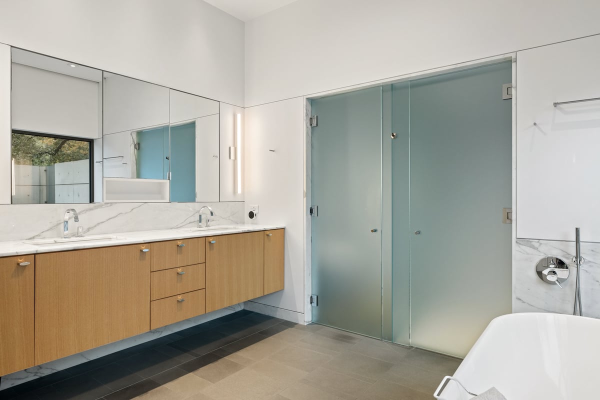 Double vanity with oak drawers, a long mirror and frosted glass doors