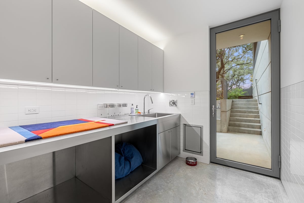 Laundry room with white cabinets and a glass door to a garden stair