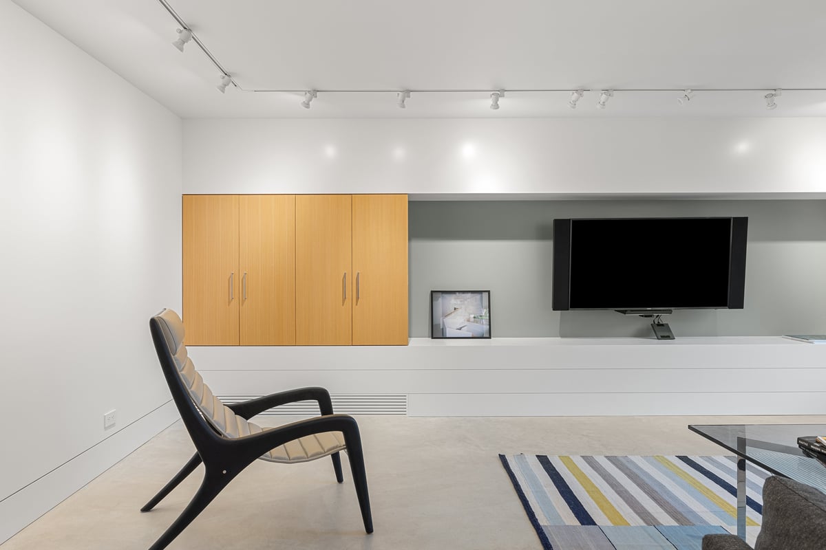 Lower level media room with oak cabinets and a lounge chair