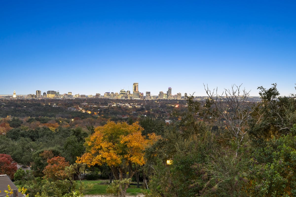 Downtown Austin skyline seen across autumn trees from the house