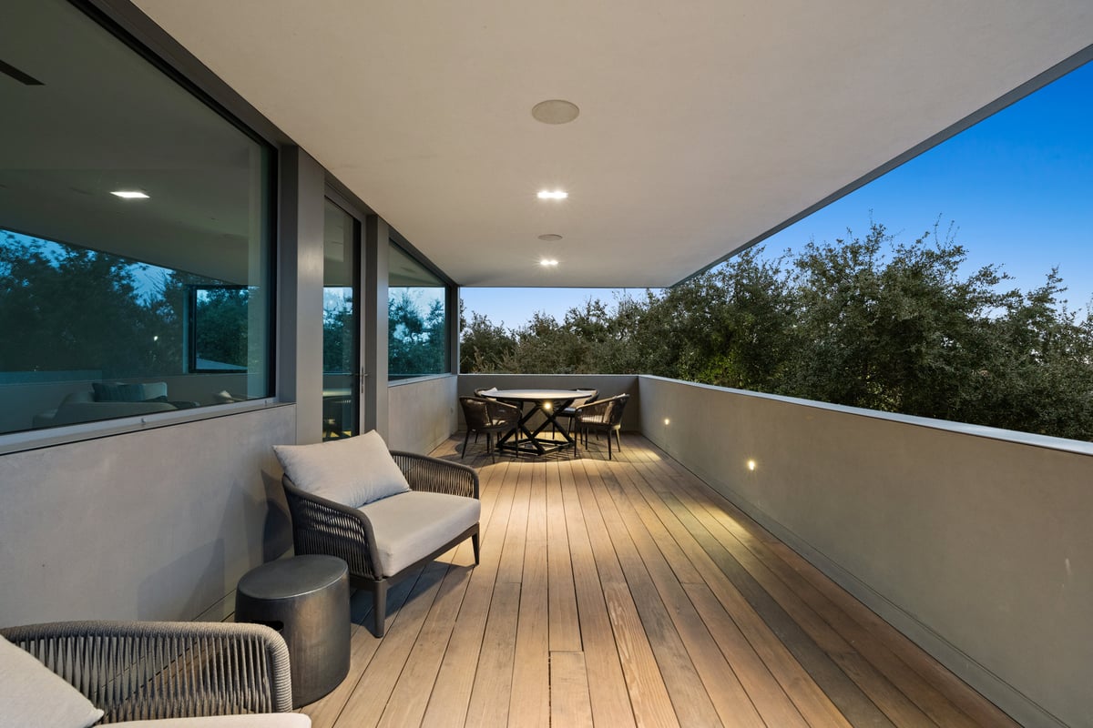 Covered upper terrace with lounge chairs and a table set toward the view