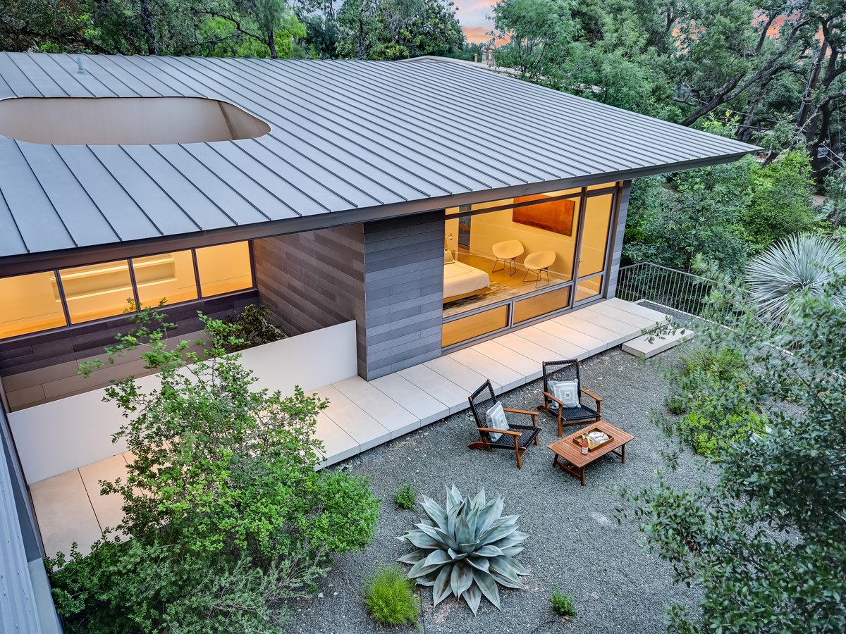 Patio with outdoor chairs under the standing seam roof and agaves
