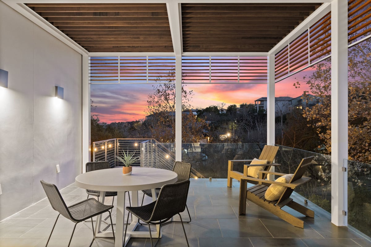The covered upper deck with dining and lounge chairs at sunset