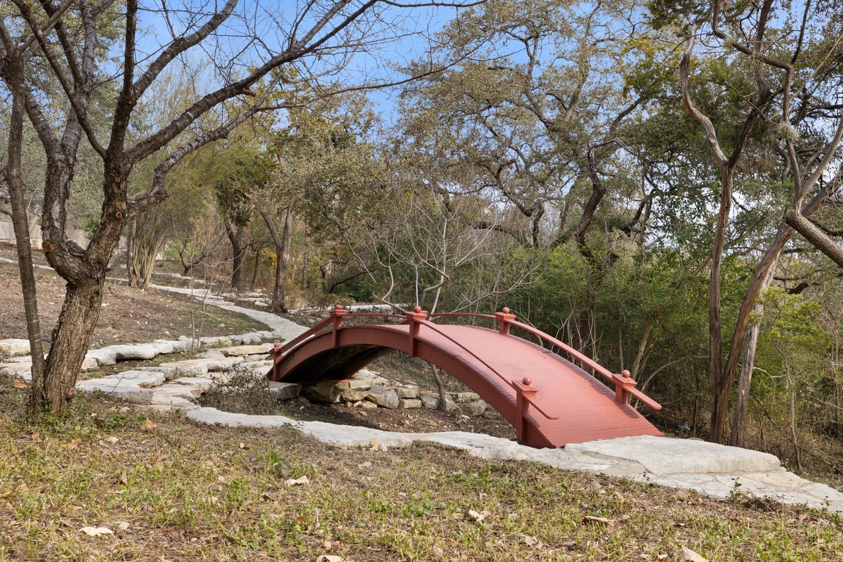 The red arched footbridge over the dry creek