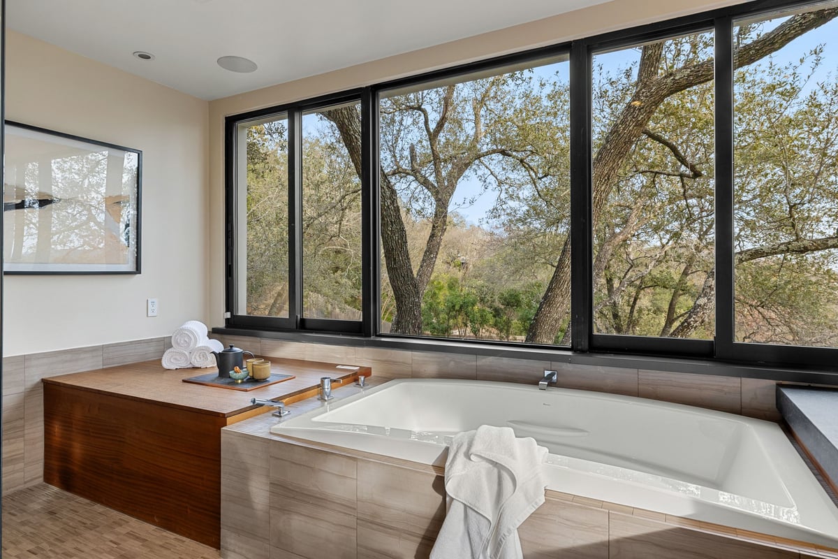The soaking tub beneath a wall of windows
