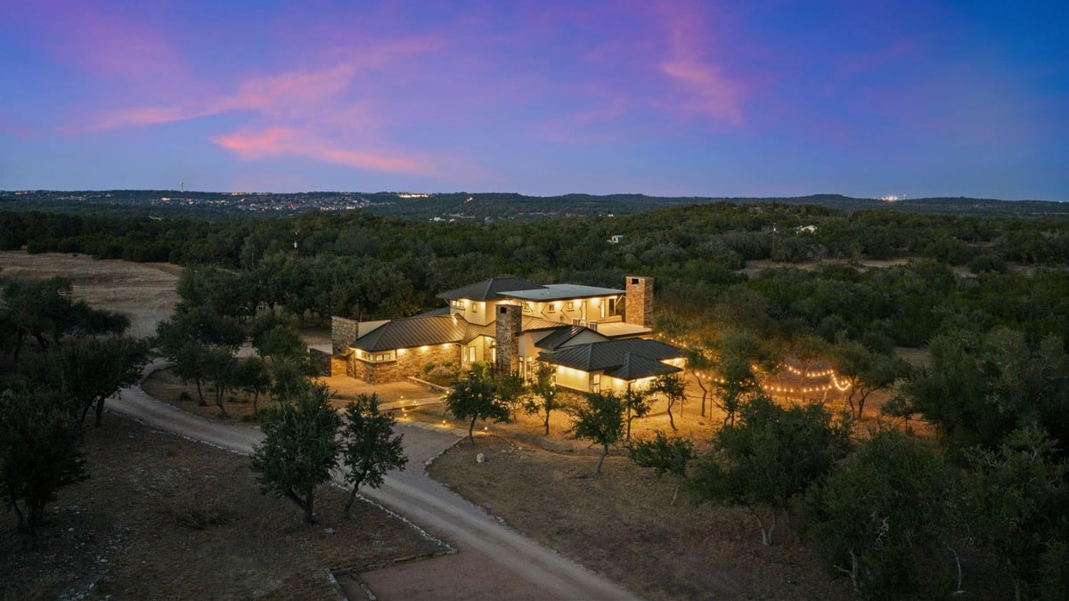 View 11600 Crumley Ranch Rd 11600 Crumley Ranch Rd - aerial view with twilight Hill Country ranch estate - Luxury home in Dripping Springs, TX