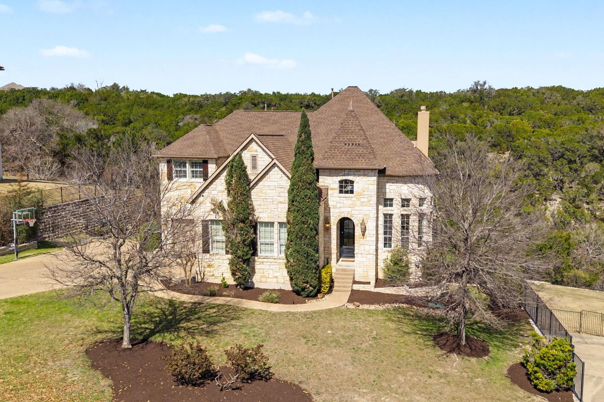 View 121 Burgess Ln in Ridge At Alta Vista 121 Burgess Ln - front exterior with stone luxury facade and arched entry - Luxury home in Ridge At Alta Vista, Austin, TX