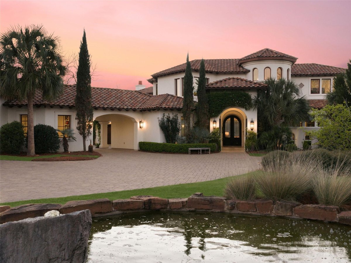 Front exterior with Mediterranean-style waterfront exterior at 14500 Flat Top Ranch Rd - 6 bed 6 bath home
