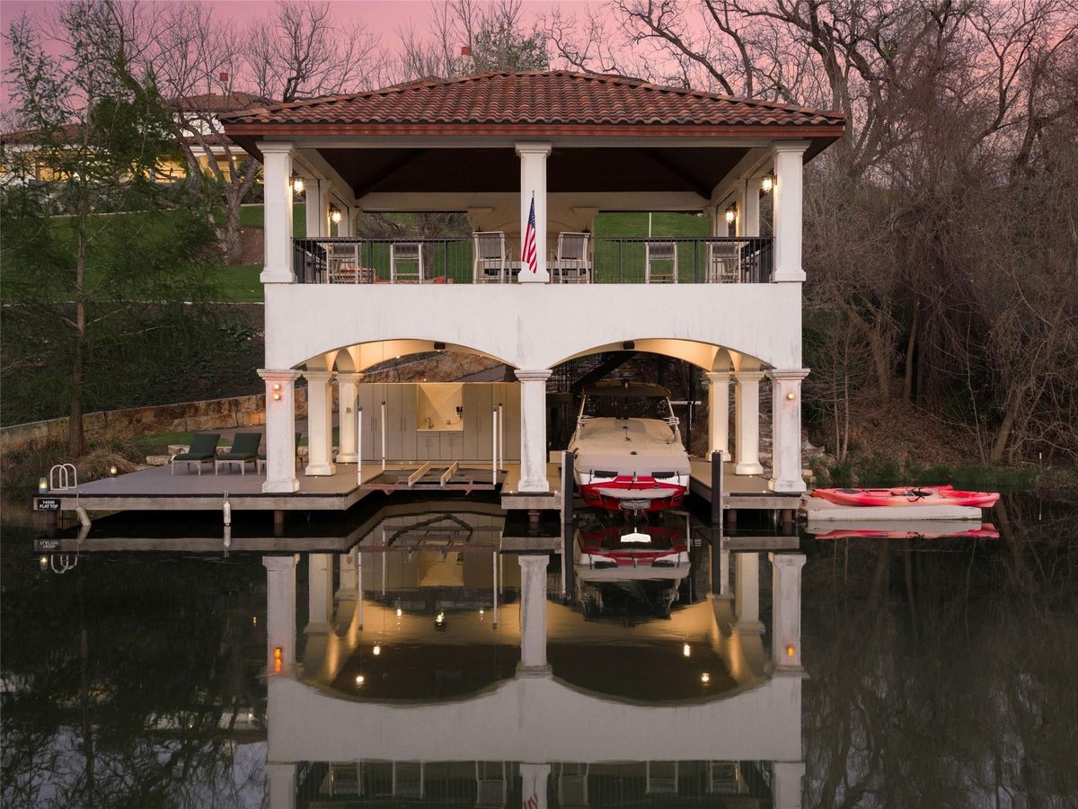 Backyard with two-level boathouse and covered dock at 14500 Flat Top Ranch Rd - 6 bed 6 bath home