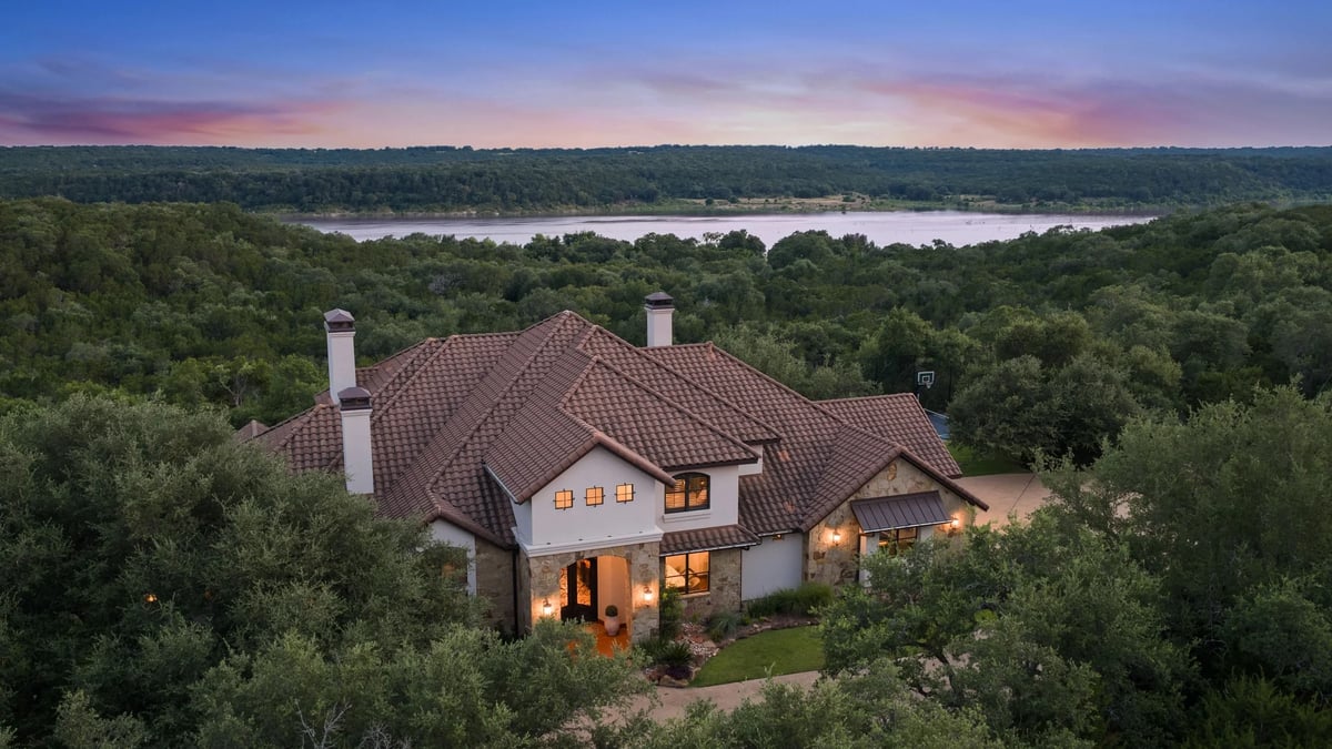 Aerial dusk view of the front facade with Lake Georgetown visible beyond the trees