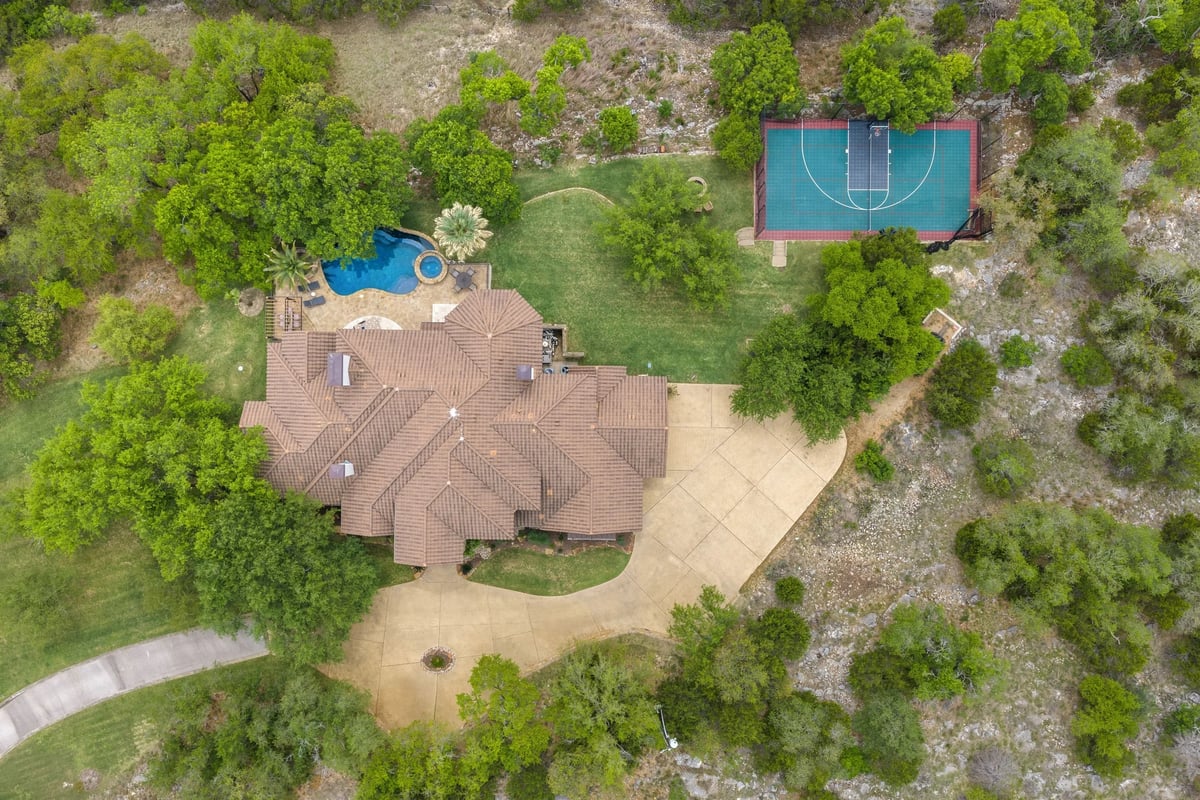 Direct overhead aerial showing the pool, hot tub, sport court, and motor court