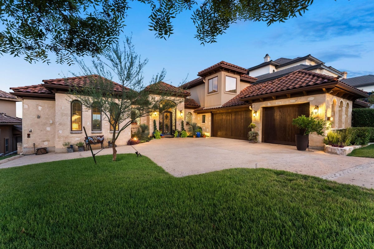 View 1901 Sea Eagle Vw in Lake Pointe Sec 07 1901 Sea Eagle Vw - front exterior with twilight Mediterranean curb appeal - Luxury home in Lake Pointe Sec 07, Austin, TX