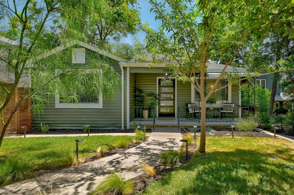 View 2109 Brackenridge St in Swisher Add 2109 Brackenridge St - front exterior with green cottage facade and covered porch - Luxury home in Swisher Add, Austin, TX