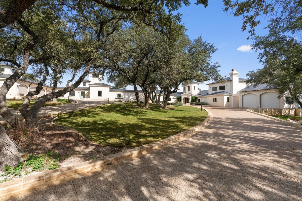 Front exterior with mature oak trees and circular driveway at 26100 Countryside Dr - 5 bed 5 bath home