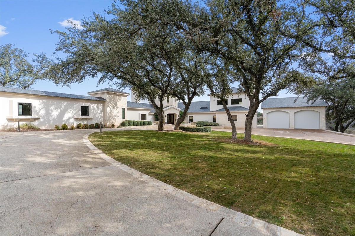 Front exterior with mature oak trees and curved driveway at 26100 Countryside Dr - 5 bed 5 bath home