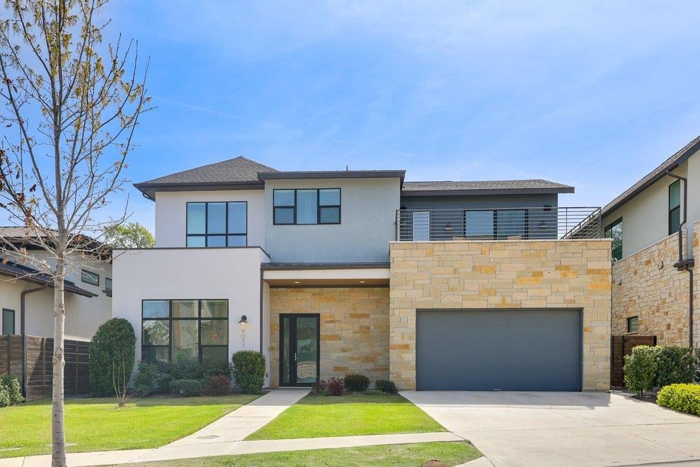 View 4011 Independent Way in The Grove 4011 Independent Way - front exterior with modern stone facade and attached garage - Luxury home in The Grove, Austin, TX