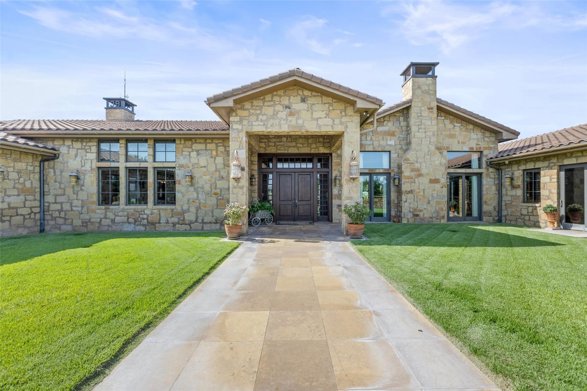 Front exterior with Ashlar stone facade at 4529 Ranch Road 3347 - 5 bed 4 bath home