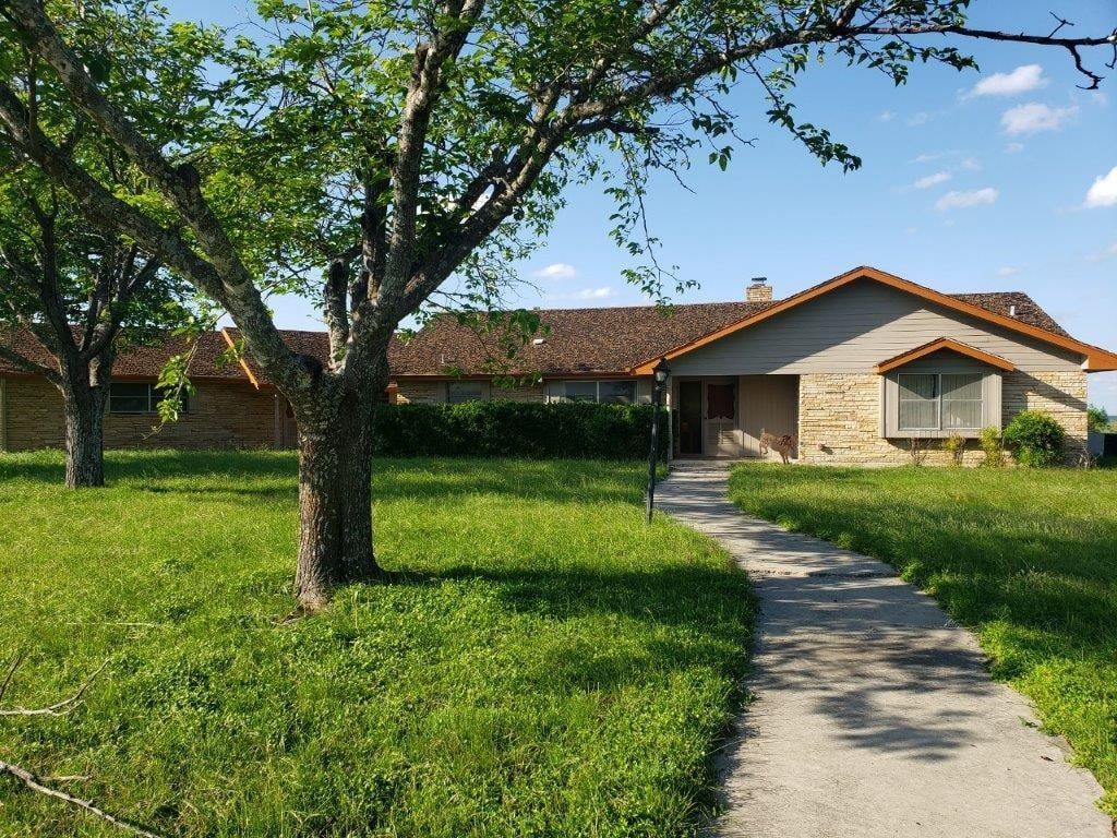 Front exterior with mature oak trees at 7947 County Road 1255 - Lampasas, TX