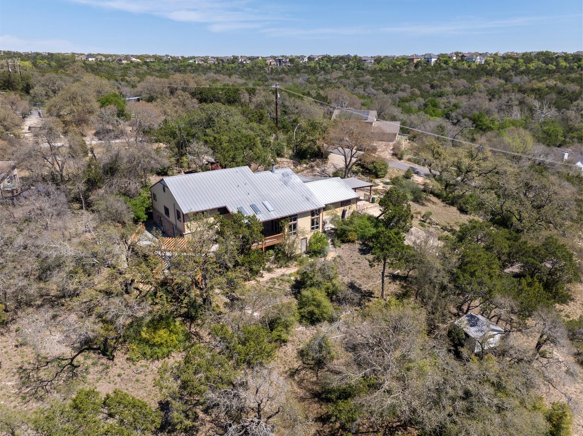 View 9106 Yucca Mountain Rd in Johnson F M 9106 Yucca Mountain Rd - aerial view with aerial wooded homesite - Luxury home in Johnson F M, Austin, TX