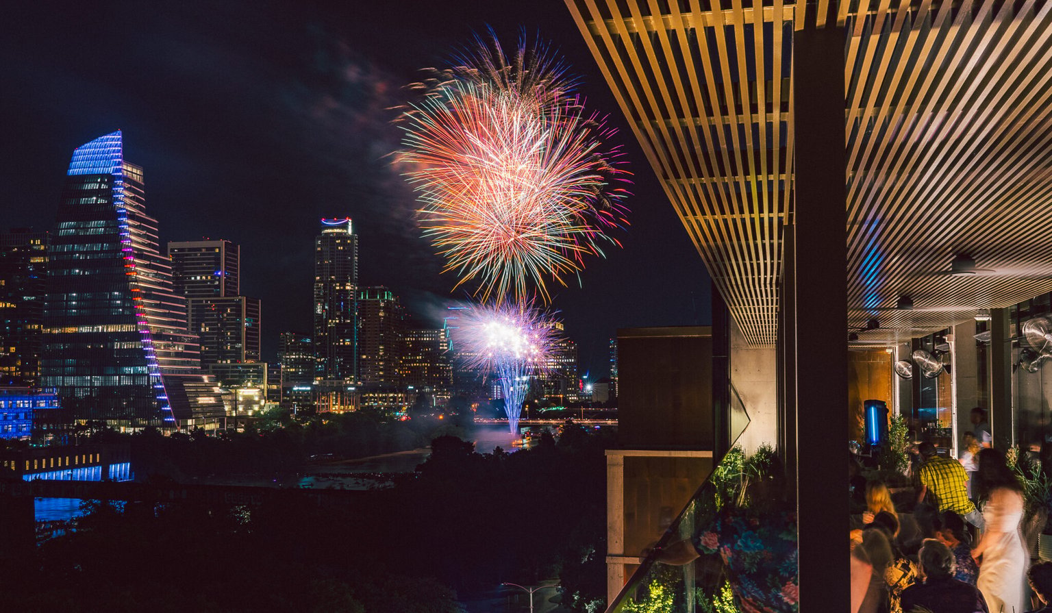 Fireworks above a waterfront at night.