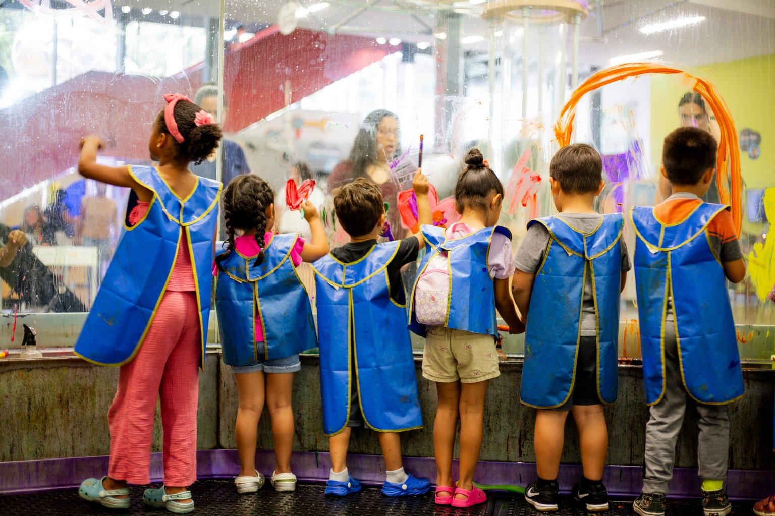 Children in capes taking part in a superhero activity.