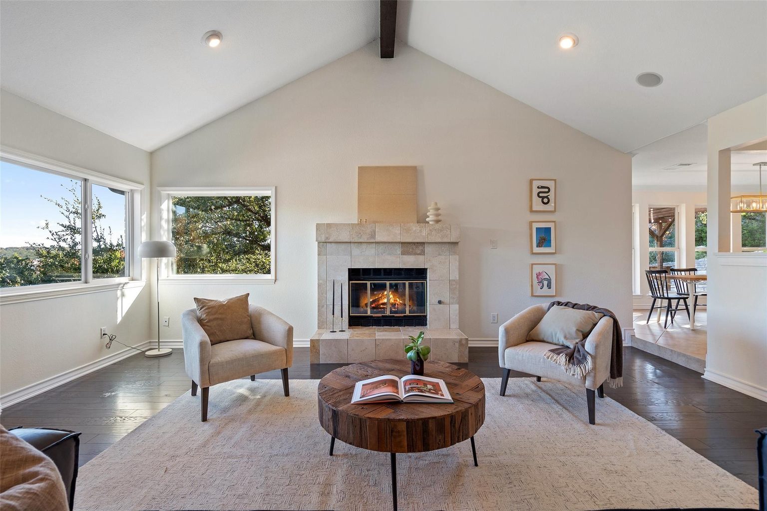 Staged living room with fireplace, vaulted ceiling and round coffee table