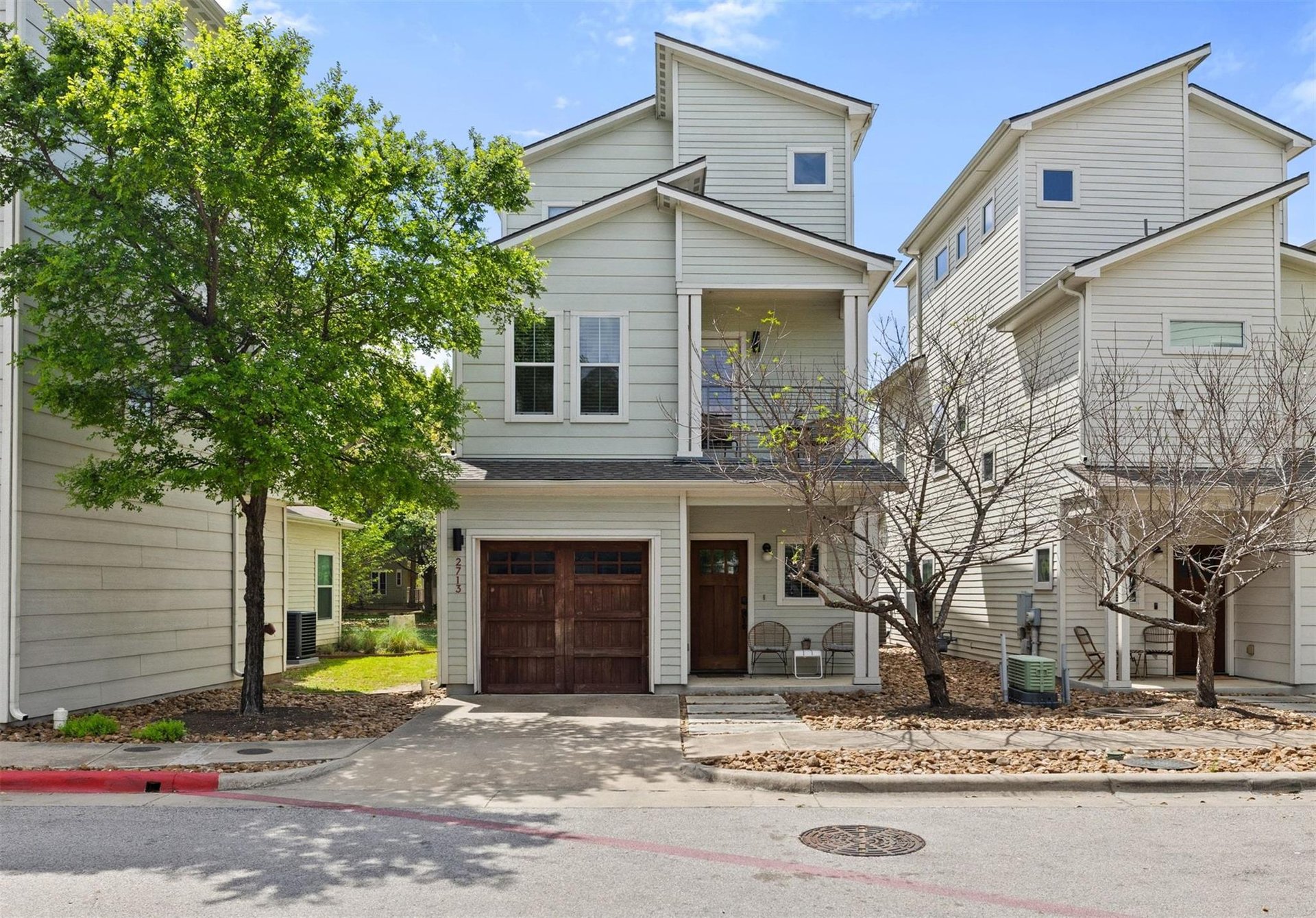 Two three-story homes with light siding and garages in 78702, Austin