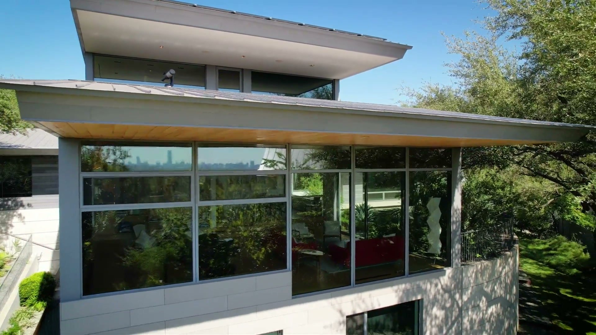 The cantilevered upper floor of 3407 Monte Vista Dr, its glass reflecting the downtown Austin skyline