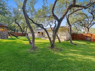 Backyard with mature trees and usable backyard at 4011 Greystone Dr - 4 bed 3 bath home