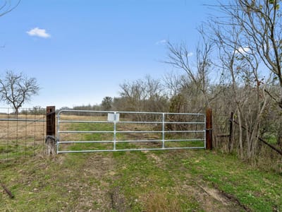 Backyard - 0 Rolling Ridge RD Backyard with Rural acreage and Metal ranch gate at 0 Rolling Ridge RD - Lockhart, Lockhart, TX