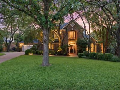Front exterior with twilight lighting and mature oaks at 10038 Circleview DR - 4 bed 3 bath home