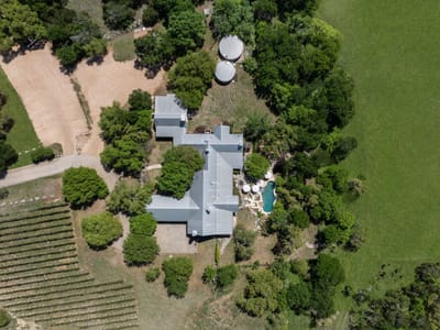 Aerial view - 18059 FM 1826 Rd Aerial view with top-down estate aerial and vineyard rows at 18059 FM 1826 Rd - Grand Cypress At Onion Creek, Driftwood, TX