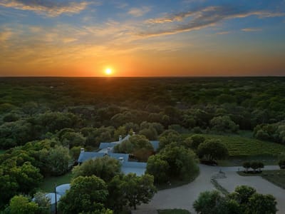 Aerial view - 18059 FM 1826 Rd Aerial view with sunset drone aerial and vineyard estate at 18059 FM 1826 Rd - Grand Cypress At Onion Creek, Driftwood, TX