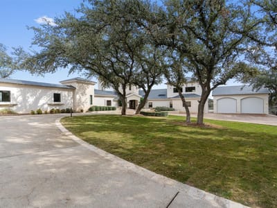 Front exterior with mature oak trees and curved driveway at 26100 Countryside DR - 5 bed 5 bath home