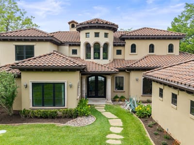 Front exterior with stucco exterior and arched windows at 3104 Rivercrest DR - 4 bed 5 bath home