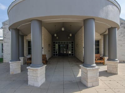 Front exterior - 400 W Old Hwy 290 Front exterior with circular portico with curved overhang at 400 W Old Hwy 290 - Philip A Smith Survey, Dripping Springs, TX