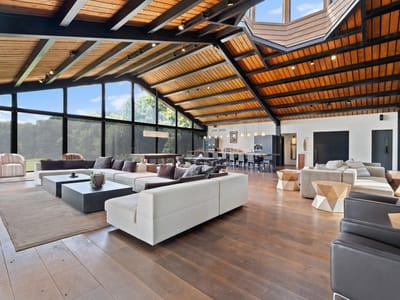 Living area with Floor-to-ceiling black-framed glass wall at 5055 Wayside Dr - None, Wimberley, TX