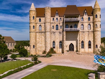 Front exterior with Castle-style architecture at 7400 Park Road 4 S - 7 bed 4 bath home